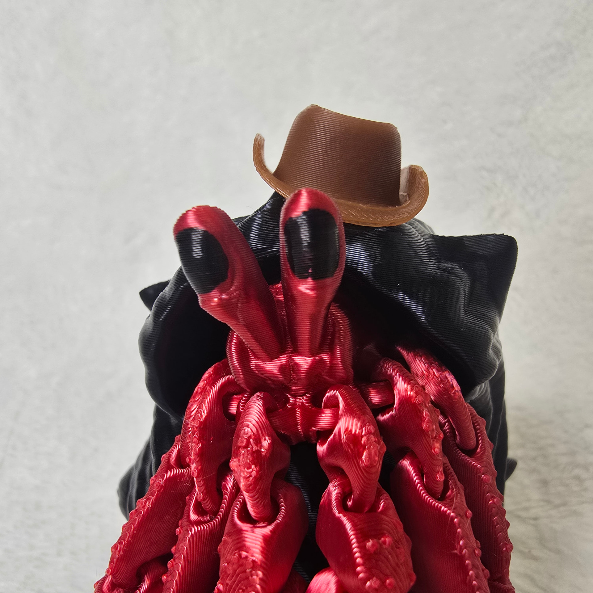Close up of a red hermit crab's eyes and claws under a cowboy hat